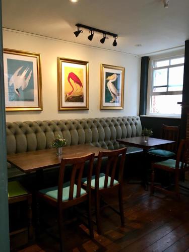 a restaurant with a table and chairs and pictures on the wall at White Hart Inn in Wells