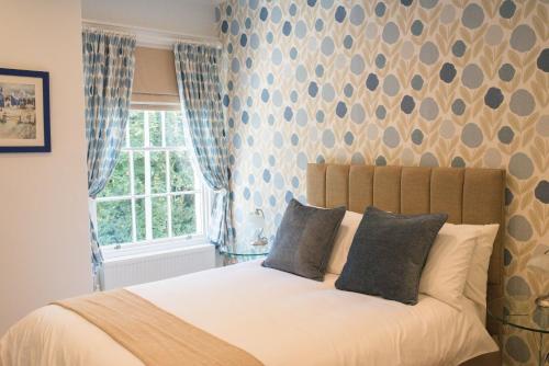 a bedroom with a bed with blue curtains and a window at The Old Parsonage in Brigg