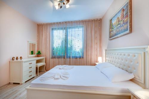 a bedroom with a large white bed and a window at Artur VIP Residence Club in Sveti Vlas