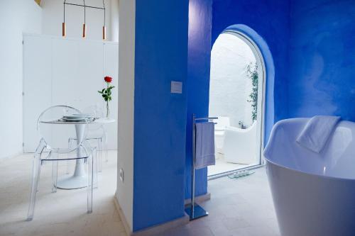 uma casa de banho azul com um lavatório e uma banheira em Divina Suites Hotel Singular -Adults Only em Ciutadella