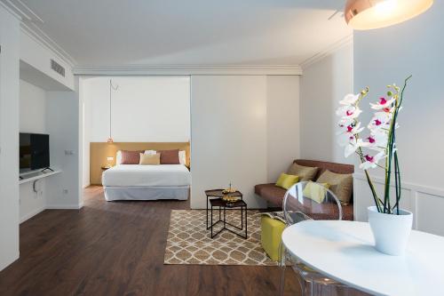 a living room with a bed and a couch at Divina Suites Hotel Boutique - Adults only in Ciutadella