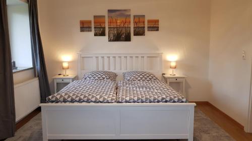 una camera da letto con un letto bianco con due lampade su due tavoli di Ruhige Ferienwohnung direkt am Nord-Ostsee-Kanal a Breiholz