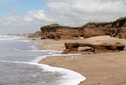 a sandy beach with rocks and the ocean at Akun Hotel in Santa Clara del Mar
