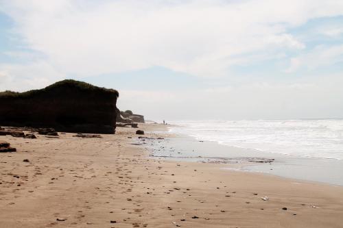 a sandy beach with rocks and the ocean at Akun Hotel in Santa Clara del Mar