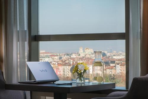 a laptop sitting on a table in front of a window at Rosslyn Central Park Hotel Sofia in Sofia