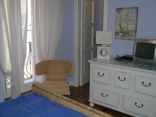 Ateleta的住宿－Appartamento ad Ateleta (Roccaraso)，一间卧室配有梳妆台、电视和椅子
