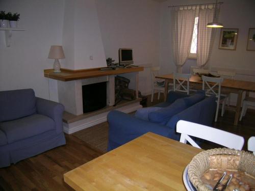 sala de estar con sofás azules y chimenea en Appartamento ad Ateleta (Roccaraso), en Ateleta