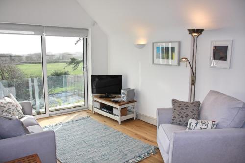 - un salon avec un canapé, une télévision et une fenêtre dans l'établissement Marshlands Apartment, à Lewes