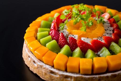 a fruit cake with strawberries and oranges on top at The Capitol Hotel Tokyu in Tokyo