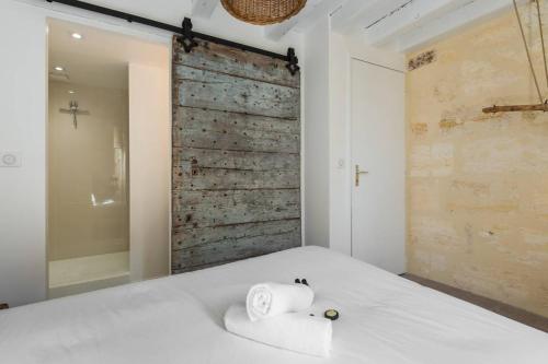 ボルドーにあるLE SECRET DE BACCHUS by Cocoonrのベッドルーム1室(白いベッド1台、タオル付)