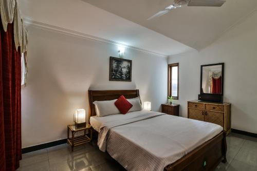 a bedroom with a large bed with a red pillow at Villa Samaara14 Candolim Beach 500mts in Candolim
