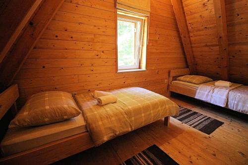 a bedroom with two beds in a log cabin at House Marko Breze in Ledenice