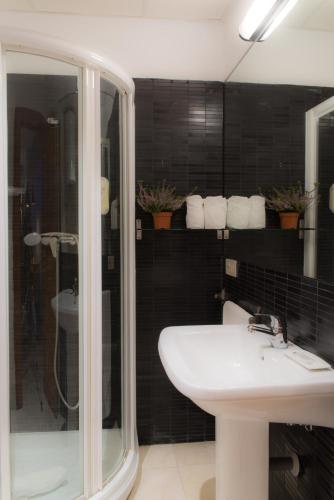 a bathroom with a white sink and a shower at Suites Campo del Príncipe by Maxi Hoteles in Granada