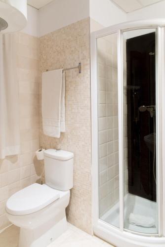a white bathroom with a toilet and a shower at Suites Campo del Príncipe by Maxi Hoteles in Granada