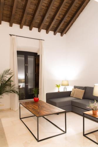a living room with a couch and a table at Suites Campo del Príncipe by Maxi Hoteles in Granada