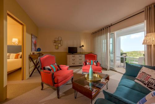 a living room with a couch and two chairs and a table at Hôtel La Réserve in Saint-Jean-de-Luz