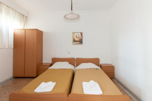 a bedroom with two beds with white towels on them at Karagiannis in Keramoti
