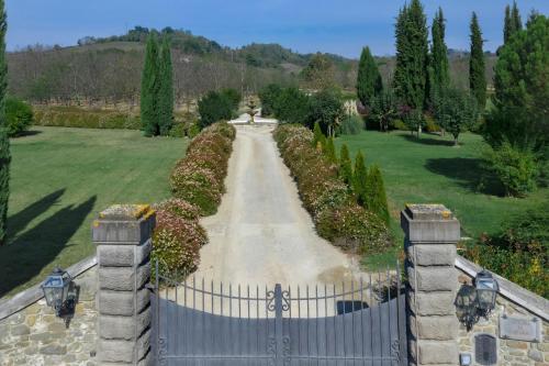 a gate to a garden with a driveway at Viesca Toscana Suites & Villas in Reggello