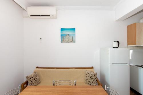 a kitchen with a wooden table and a refrigerator at Karagiannis in Keramoti