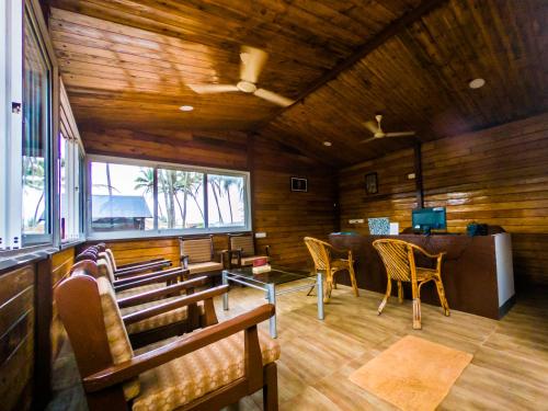 Habitación con paredes y sillas de madera y mesa. en Vista Praia Beach Resort, en Anjuna