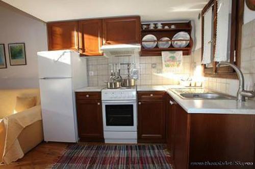 a kitchen with a white refrigerator and a sink at Traditional studio in Skiros