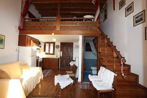 a living room with a couch and a loft at Traditional studio in Skiros
