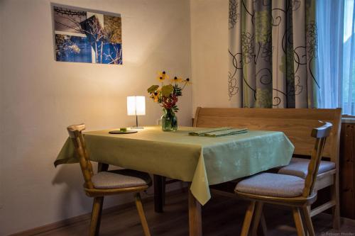a dining room table with chairs and a vase of flowers at Haus Kristall in Bach