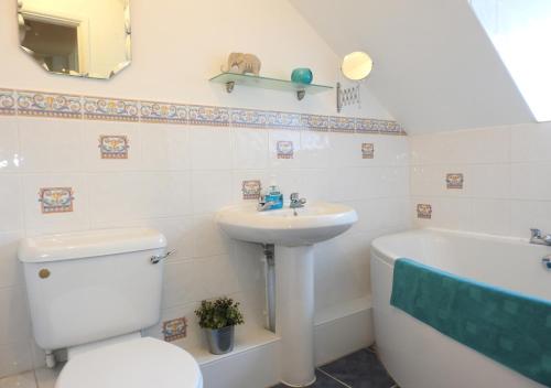 a bathroom with a toilet and a sink and a tub at Century House in Gosport