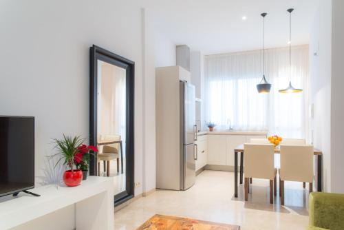 a kitchen and dining room with a table and a mirror at Suites Campo del Príncipe in Granada