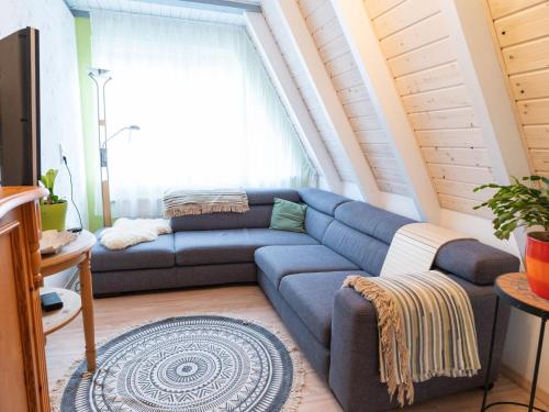 Holiday home in Bestwig with private garden في بيستفيغ: غرفة معيشة مع أريكة زرقاء أمام نافذة