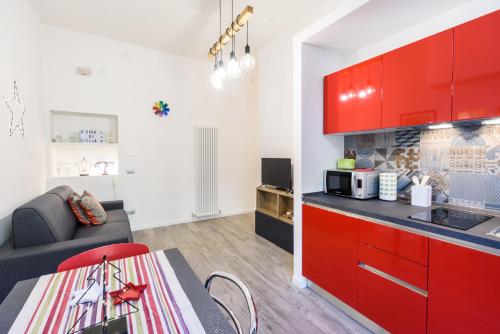 a kitchen with red cabinets and a living room at A casa di Stella House in Venezia in Mestre
