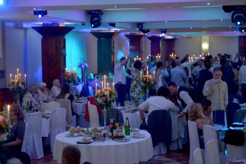a group of people sitting at tables in a banquet hall at Hotel Centar Balasevic in Belgrade