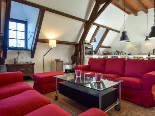 a living room with red couches and a table at Holiday home with swimming pool in Saint-Laurent-la-Vallée