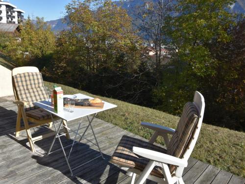 サランシュにあるSpacious Apartment in Sallanches near Ski Areaのデッキにテーブルと椅子2脚