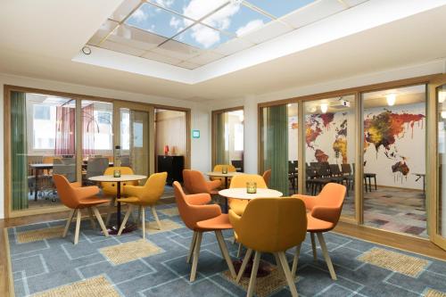 a dining room with tables and chairs and a skylight at ProfilHotels Hotel Garden in Malmö