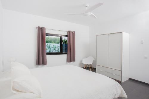 a bedroom with a white bed and a mirror at ICONIC VILLA LANZAROTE in Mácher