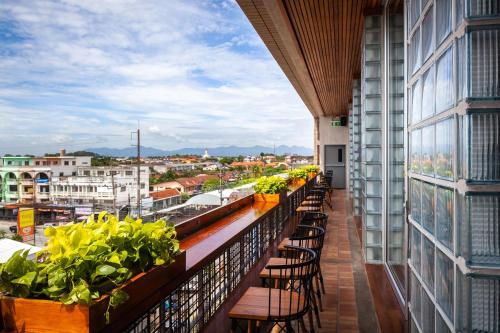 a balcony with chairs and plants on a building at Laekhon Nonbai in Nakhon Si Thammarat