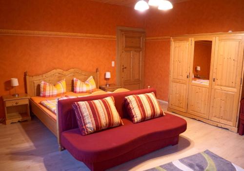 a bedroom with a bed and a couch with pillows at Pension Post in Twiste
