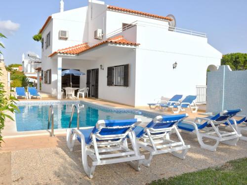 ヴィラモウラにあるSpacious Holiday Home in Vilamoura with Private Poolのスイミングプール、ラウンジチェア付きのヴィラ