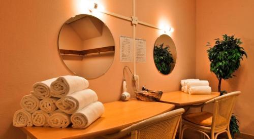 a room with a desk with a pile of towels at 't STRANDHUYS en DE VUURTOREN, met eigen KEUKEN, ZONNIG TERRAS nabij DORP, DUINEN en STRAND, Incl verwarmd binnen ZWEMBAD in Hollum