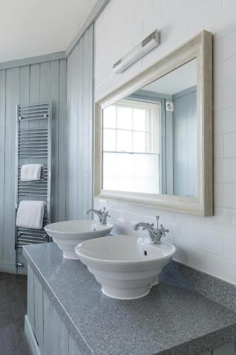 a bathroom with two sinks and a large mirror at Royal Hotel in Deal