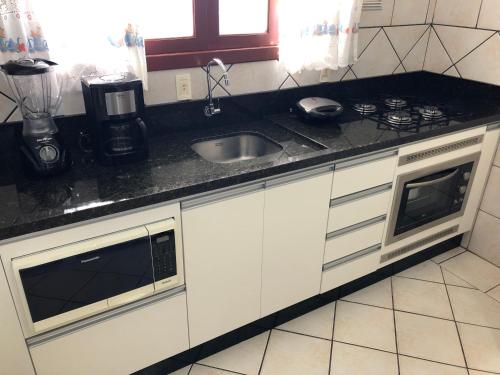 a kitchen with a sink and a counter top at Pousada Açoriana in Florianópolis