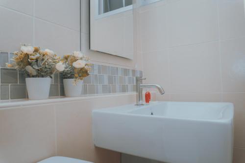 bagno con lavandino, specchio e fiori di Baan Peang Ploen Huahin A 6/416 a Hua Hin