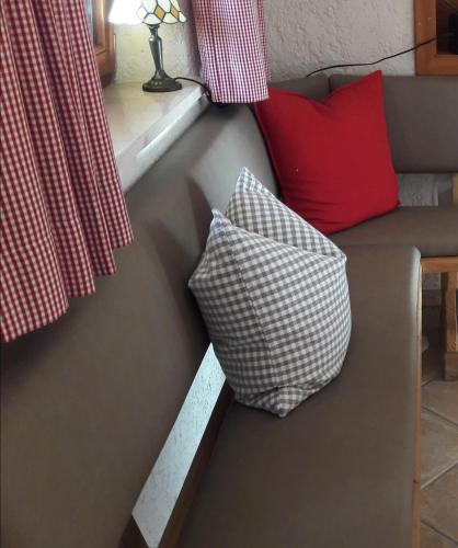 a couch with two pillows on it with a window at Villa Casa in Bad Tölz