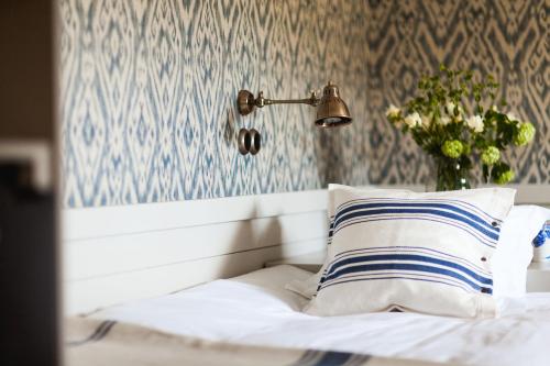 a bed with a lamp and a pillow on it at Bauergården in Gränna