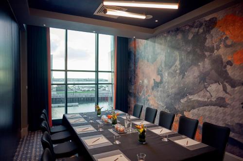 a dining room with a long table and a large window at Malmaison Liverpool in Liverpool
