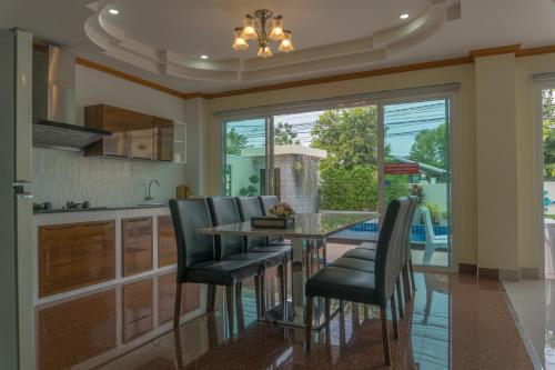 a kitchen with a glass table and black chairs at Sea you pool villa Hua Hin in Hua Hin