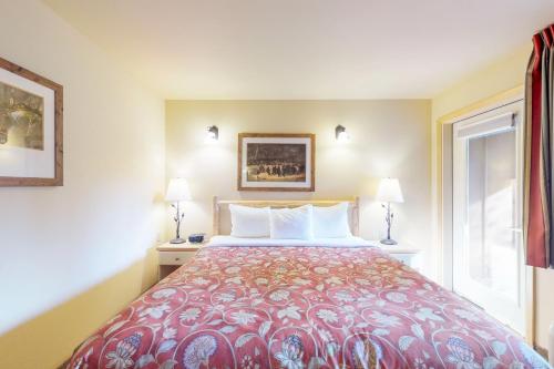 a bedroom with a bed and two lamps and a window at Aspen Suites 506: The Nest in Leavenworth