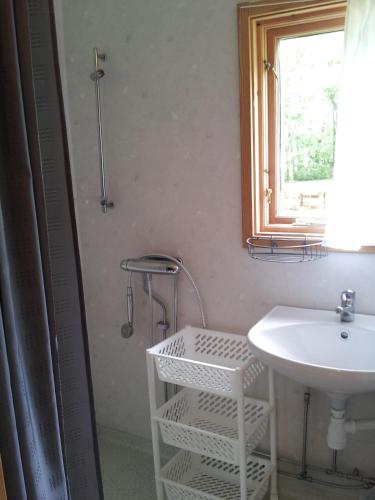 a bathroom with a white sink and a window at Chokladvillan in Visby