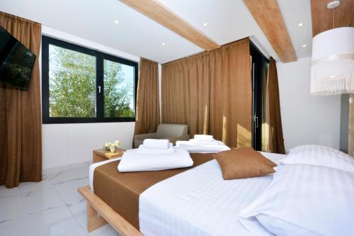 a bedroom with two beds and a large window at Hotel San Antonio in Podstrana